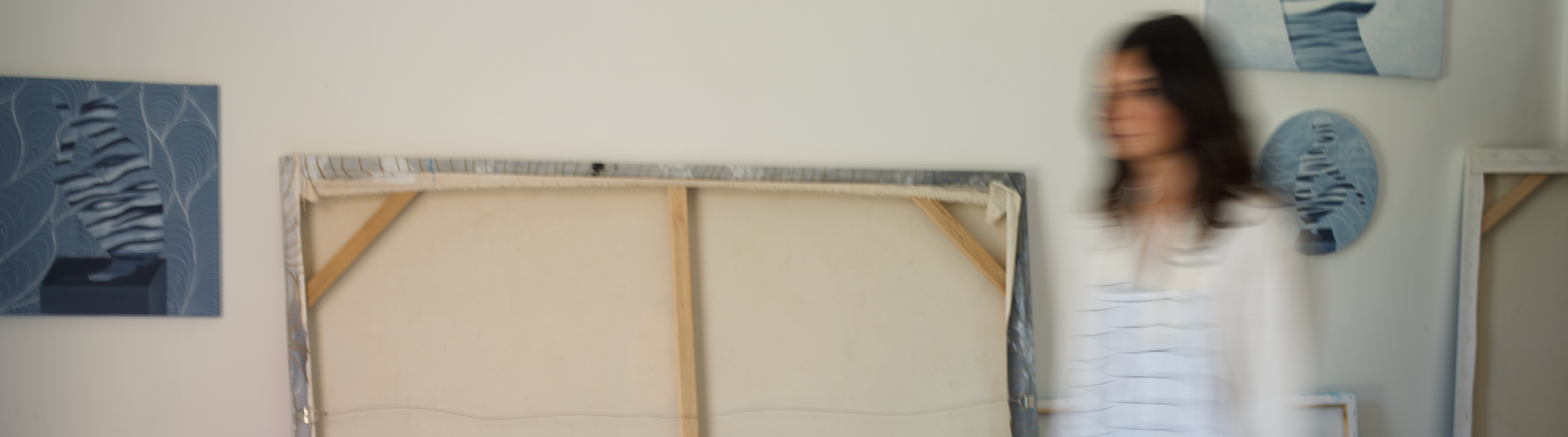 Person walking past a large framed artwork of a zebra in an indoor setting.